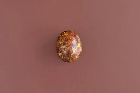 One egg, painted in brown colors, on brown background. Minimalism concept Stock Photos