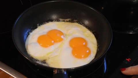 One egg, two yolks. Cooking scrambled eggs with two yolks. Stockbeeldmateriaal 250237080