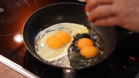 One egg, two yolks. Cooking scrambled eggs with two yolks. Stockbeeldmateriaal 250237102