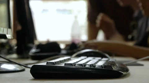 One employee says something to another who works at the computer, out of focus Stock Footage 81722350