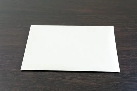 One empty blank sheet of paper placed on the dark wooden surface Stockfoto's