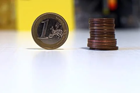 One euro coin and stack of cents on blurred background Stock Photos