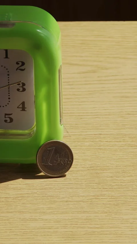 A one-euro coin next to the moving second hand of a clock Video stock 337954837