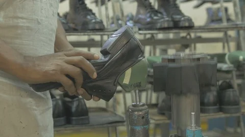 One of the final steps of shoe making in a factory Stock Footage 108477057