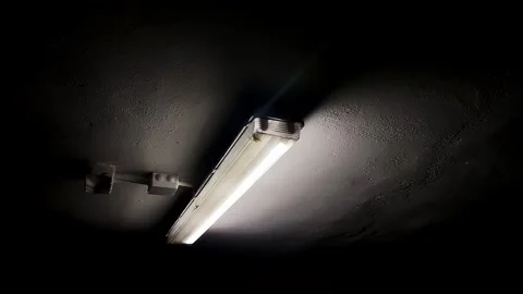 One flickering daylight lamp on the ceiling as a result of a power surge Stock Footage 246556568