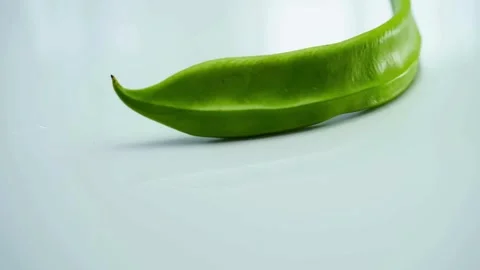 One fresh green winged bean rotating on white background Stock Footage 333811115