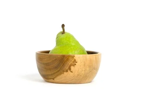 One fresh Packham pears fruit above wooden bowl isolated on white background Фото