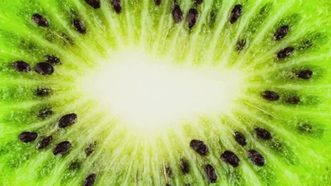 One fresh ripe cuted kiwi is moving away and spinning on pink background Stock Footage 100399349
