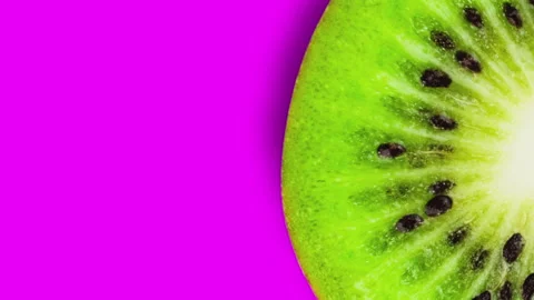 One fresh ripe cuted kiwi is spinning on pink background Stock Footage 101018401