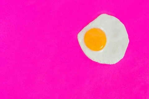 One fried egg on pink background, pop art, isolated from the right side Stock Photos