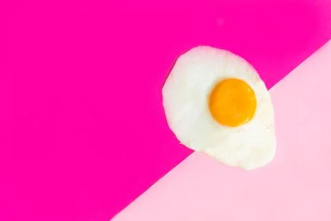 One fried egg on pink background, pop art, isolated from the right side Stock Photos