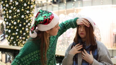 One friend checks temperature of another feeling sick during christmas time Stock Footage 325212682