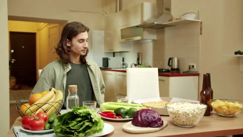 One of friends is sitting down at the table while his pal is entering the Stock Footage 160177222