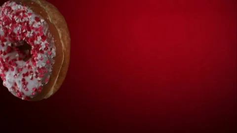 One frosted donut falling through the air with sprinkles Stock Footage 327632334