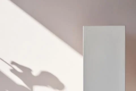 One geometric rectangular podium on a light background with a shadow. A white Fotos de archivo