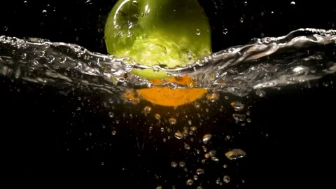 One Green Apple and Two Oranges  Fall Into Water. Slow motion Video Stock Footage 91703512