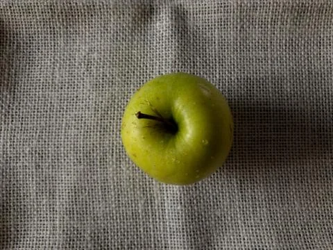 One green Apple is on the table. The view from the top. Stock Photos