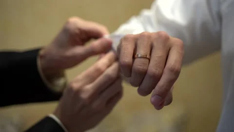 One guy helps another to put on a white shirt Stock Footage 142203489