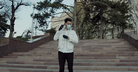 One guy with a protective mask walking and use your mobile phone Stock Footage 129849805