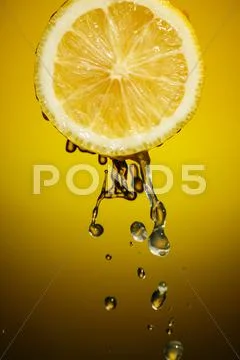 One half of lemon with fresh water drops isolated on colorful background Stock Photos