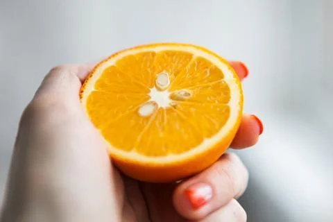 One half of orange in somebody's hand Stock Photos