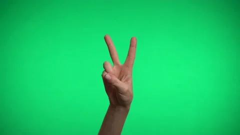 One hand on a green background shows the sign of peace. Video stock 163600307
