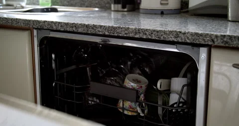One hand opens the dishwasher and pulls out a glass Stock Footage 270084772