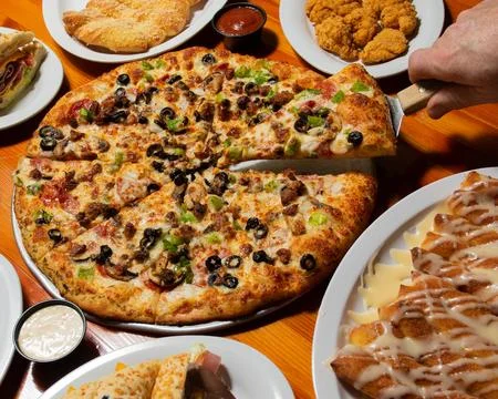 One hand taking a slice of pizza Stock Photos