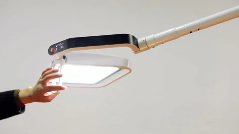 One hand is twisting the surgical light for adjustment. Vídeos de archivo 130936068