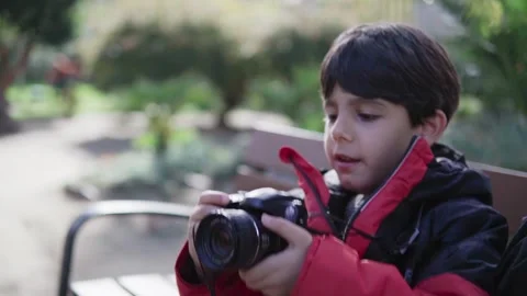 One happy child sitting on a bench of the park Stock Footage 258374161