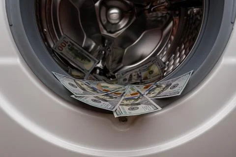 One hundred dollar bills inside open washing machine drum closeup Fotos Stock