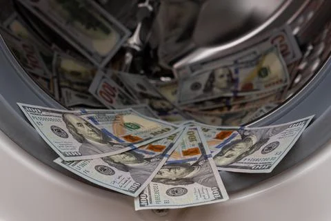 One hundred dollar bills inside open washing machine drum closeup Fotos Stock
