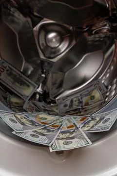 One hundred dollar bills inside open washing machine drum closeup Photos