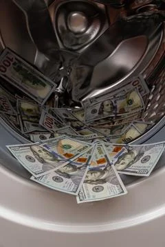 One hundred dollar bills inside open washing machine drum closeup Fotos Stock