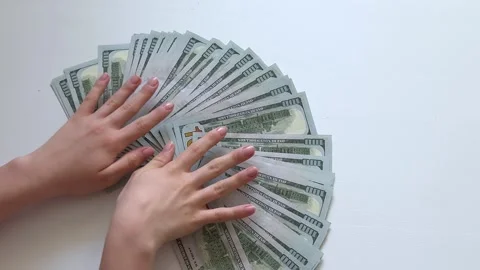 One hundred dollar bills spread into wide fan by female hands on white Stock Footage 345182643