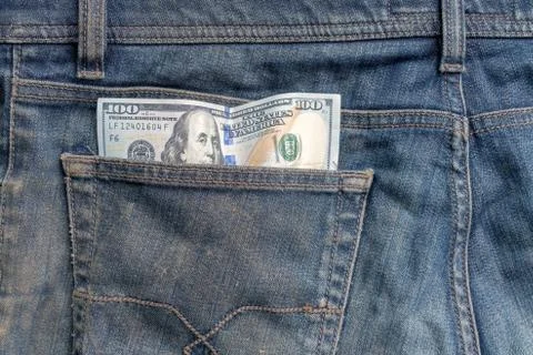 A one hundred dollar note in the back pocket of blue jeans Stock Photos
