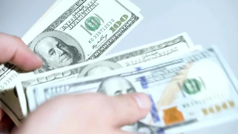 One hundred dollars banknotes pack in hands. Male hands counting dollar cash in Stock-Footage 336263147