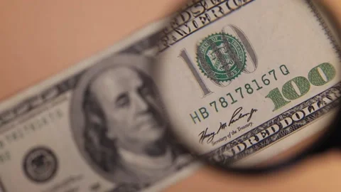 One hundred dollars inspecting under magnifying glass, loupe. Counterfeit money Stock Footage 227358505