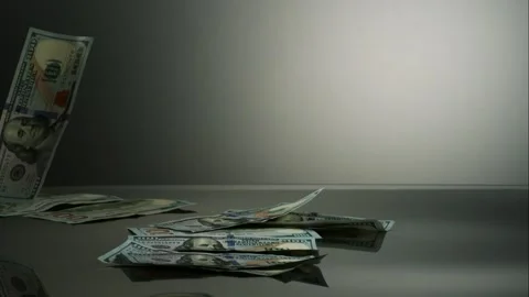 One Hundred US Dollar Bills Falling Slowly Onto A Dark Stock Footage 326290724