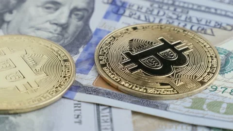 One hundred US dollars and Bitcoin BTC coins, cryptocurrency and virtual money Stock Footage 170672968