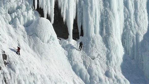 One ice climber ascends while the other descends an icy cliff in Alberta 動画素材 90876350