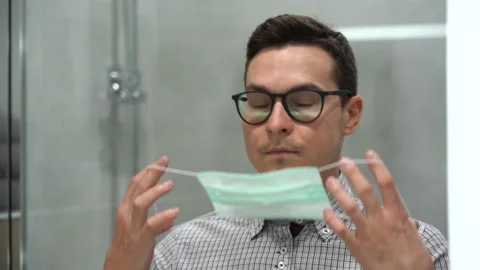 One Illness guy in front of mirror wear black glasses, protective face mask Stock Footage 131461517