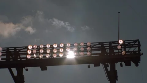 One illuminated light between non-functional lights in stadium Stock Footage 104770095