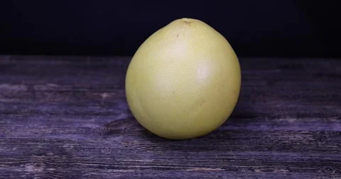 One large citrus on a black table and on a black background, ripe citrus fruit Stock Footage 311793366