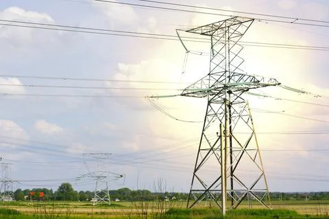 One large pole with electrical wires in the field Stock Photos