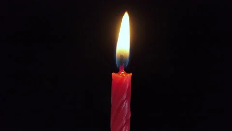 One large red candle lights up and goes out, isolated on a black background Stock Footage 220744653