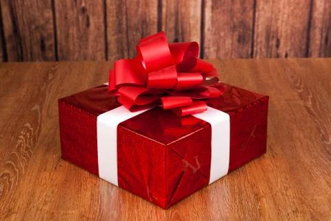 One large red gift box on a wood Stock-Fotos