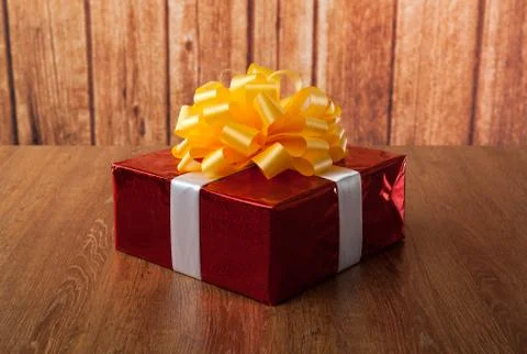 One large red gift box on a wood Stock-Fotos
