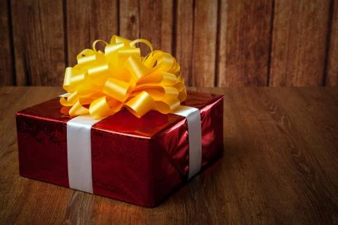 One large red gift box on a wood Stock-Fotos