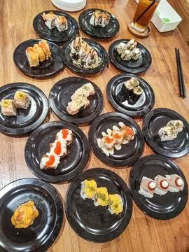 One large table contains many sushi plates in a Japanese restaurant Stock Photos
